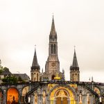 Vista da Basílica de Nossa Senhora do Rosário, em Lourdes, na França, sob um céu claro.
