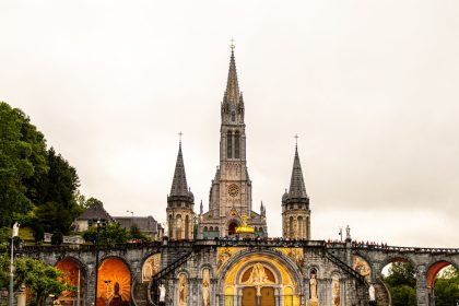 Vista da Basílica de Nossa Senhora do Rosário, em Lourdes, na França, sob um céu claro.