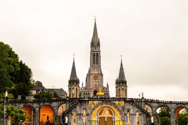 Vista da Basílica de Nossa Senhora do Rosário, em Lourdes, na França, sob um céu claro.