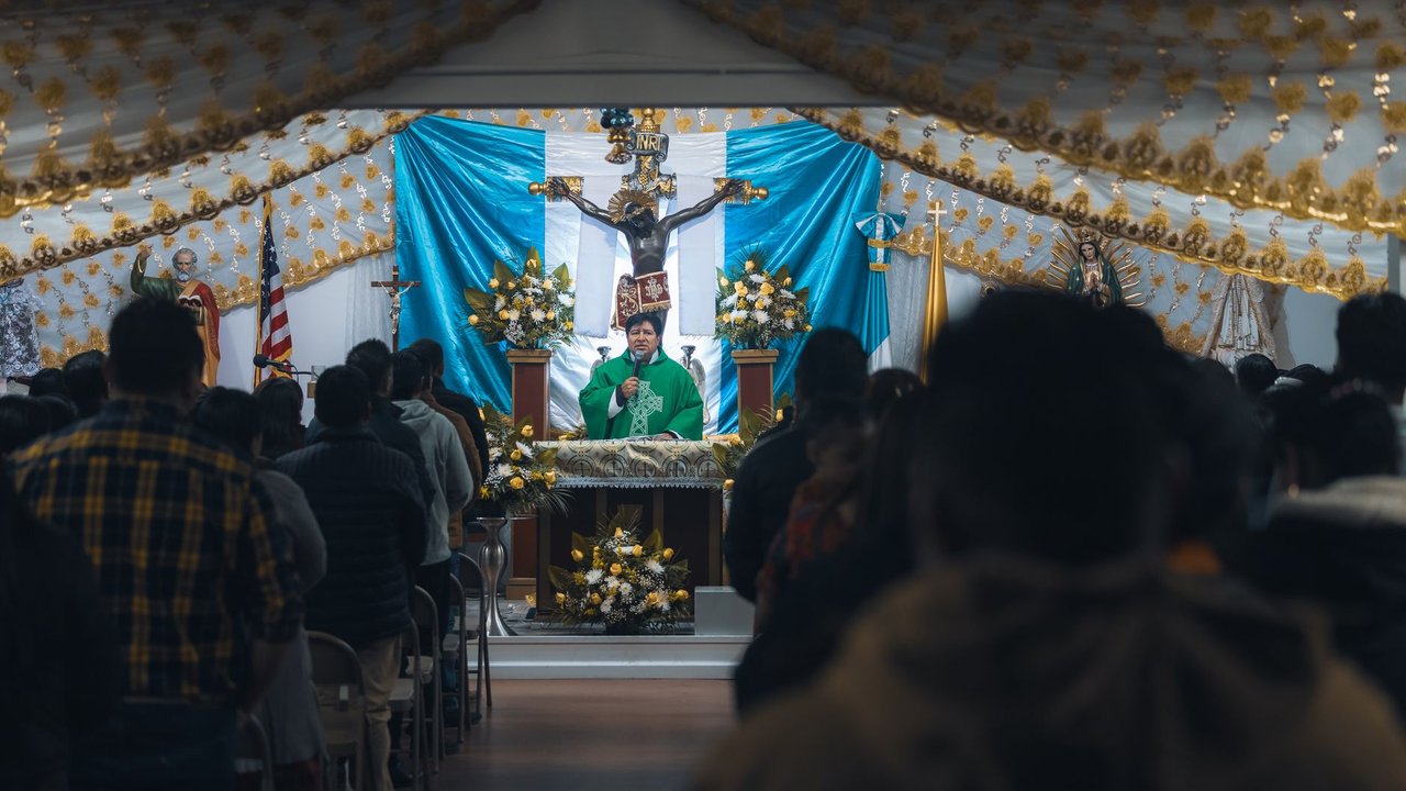 Sacerdote faz um sermão diante dos fiéis em uma igreja ornamentada