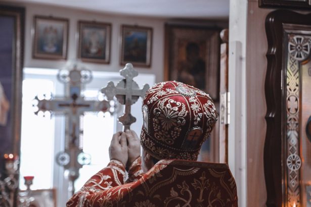 Bispo segurando uma cruz durante uma cerimônia religiosa dentro de uma igreja