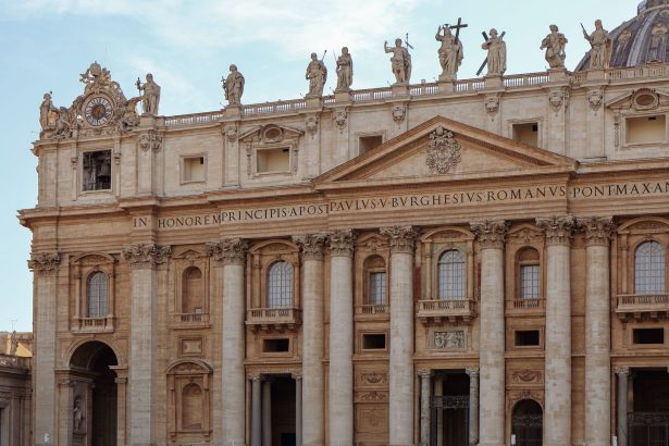 Fachada da Basílica de São Pedro, no Vaticano, com estátuas e colunas sob céu claro