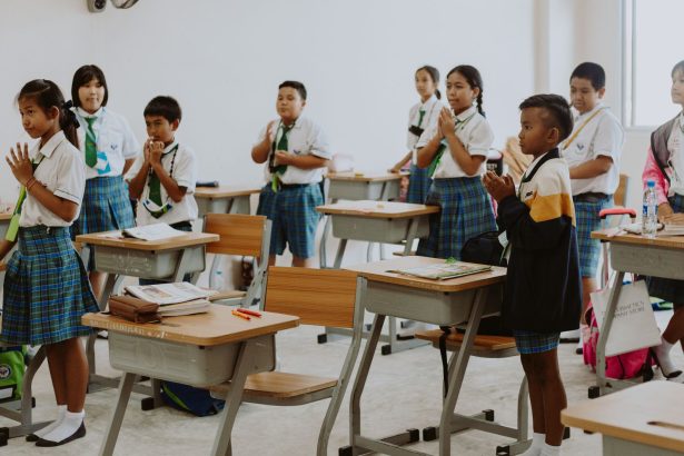Estudantes uniformizados participam de uma atividade em sala de aula.