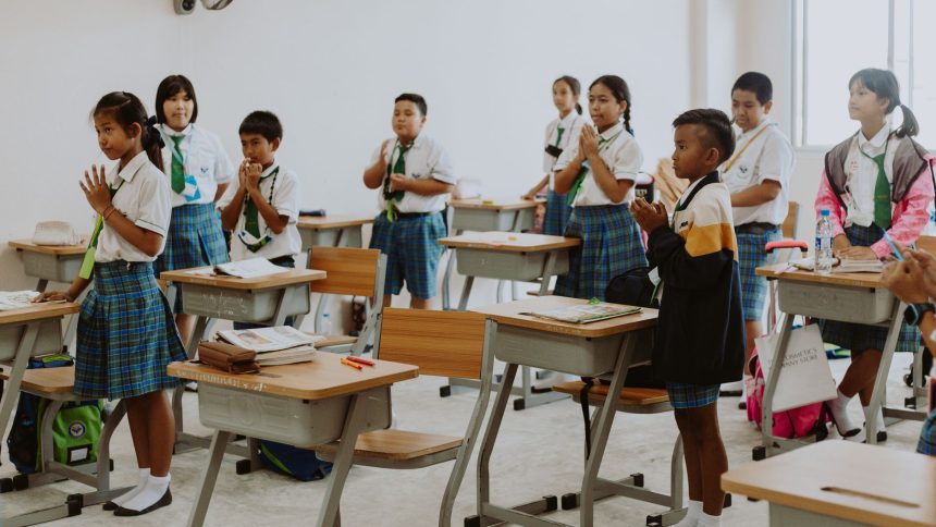 Estudantes uniformizados participam de uma atividade em sala de aula.